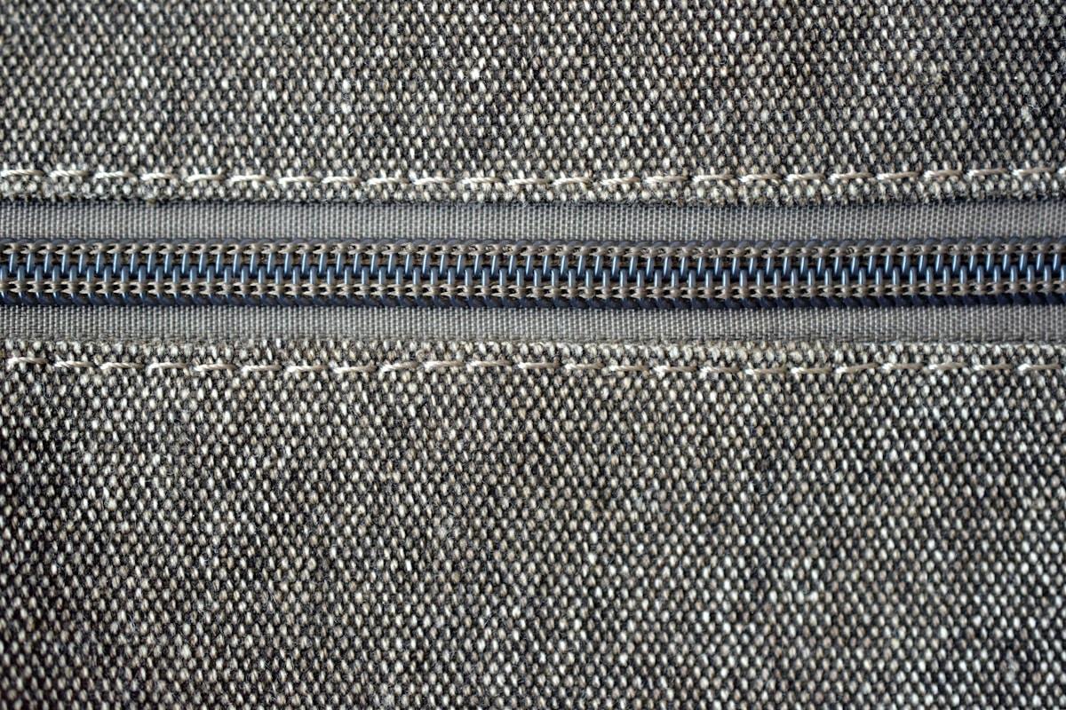 Close-up of a lock-tab zipper pulled tight on a cat backpack